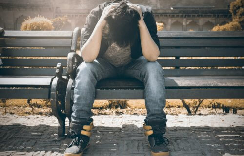 Teen or college student alone, stressed, depressed on bench