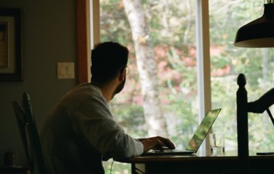 Man sitting at desk and looking outside window