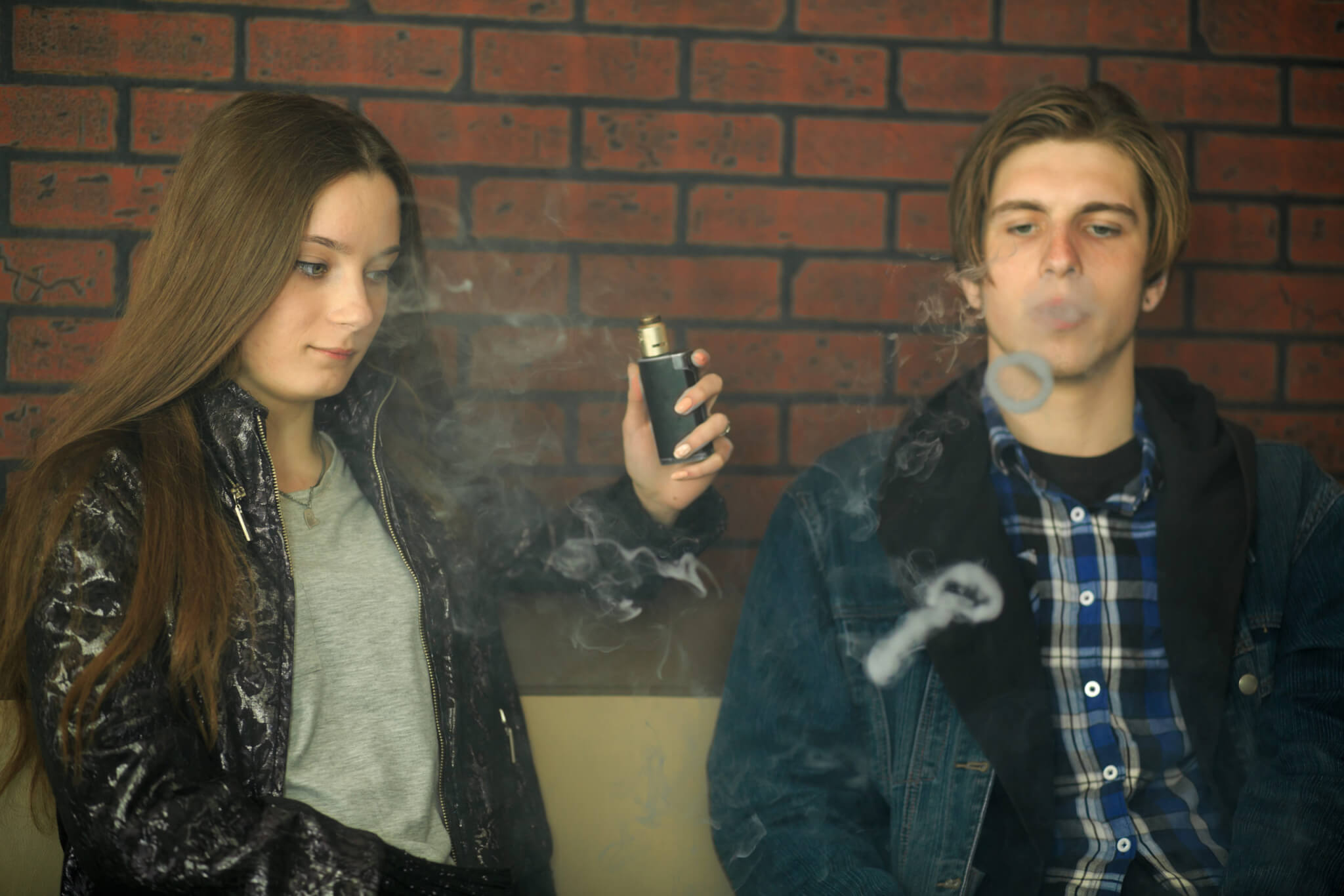 Teens vaping and blowing smoke