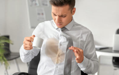 Man with coffee stain on shirt at work