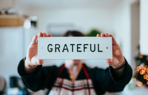 Person holding 'Grateful' sign