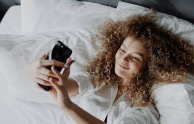Woman taking selfie in bed