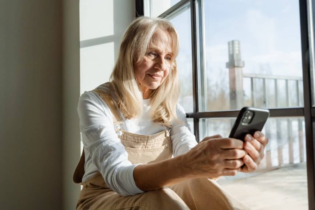 Older woman alone, using smartphone