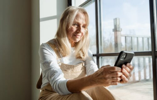 Older woman alone, using smartphone