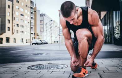 Man tying his running shoes before jogging or exercising