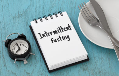 Intermittent fasting concept on blue table