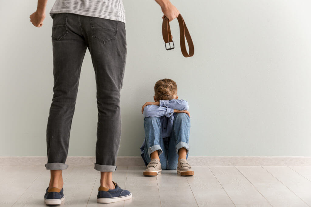 Man preparing to spank or use corporal punishment on his child with belt