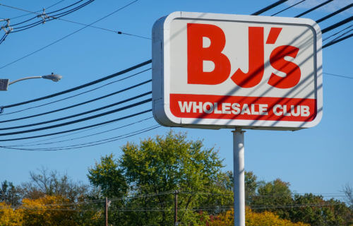 A red sign for BJ's Wholesale club as seen on the side of a road