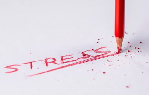 Stress written on paper with red pencil point breaking