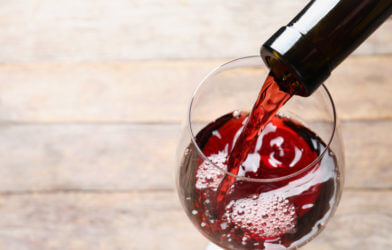 Pouring red wine from bottle into glass