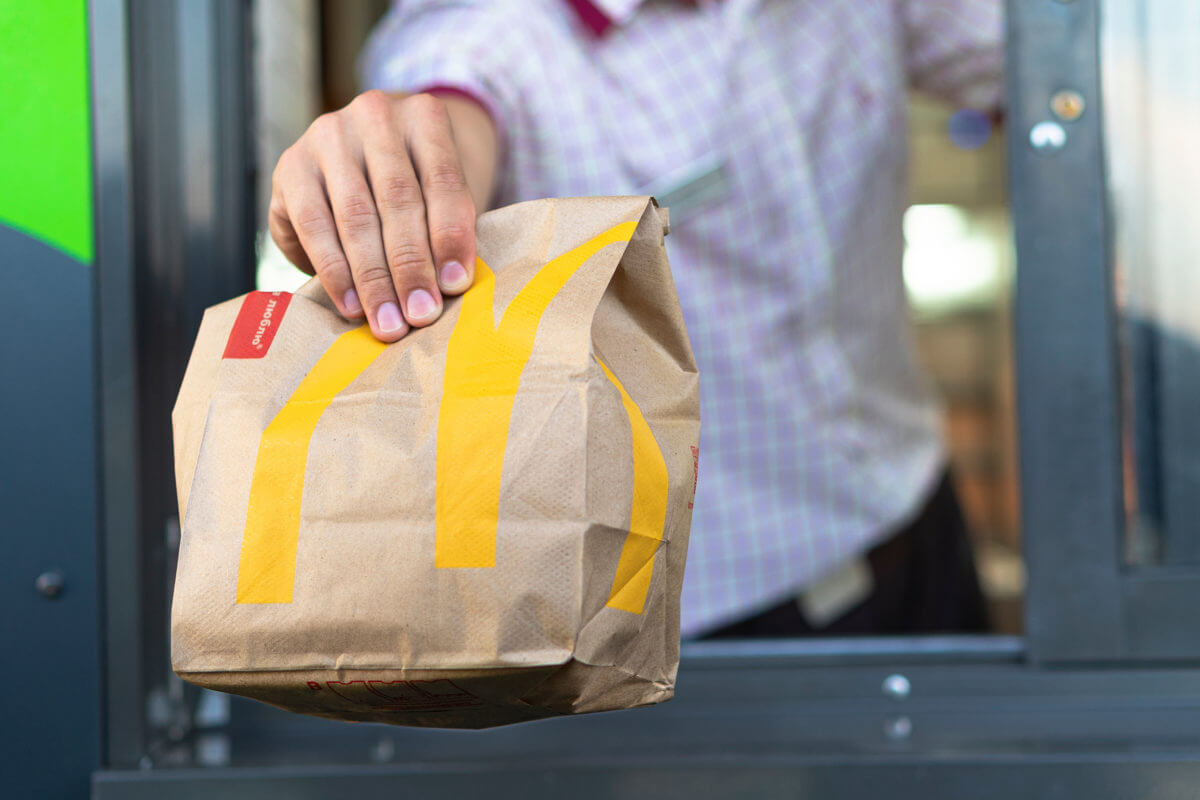 McDonald's drive-thru worker holding bag of food