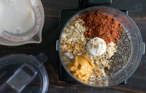 Chocolate Overnight Oatmeal Smoothie Ingredients: Rolled oats, chia seeds, and other breakfast smoothie ingredients in a food processor bowl
