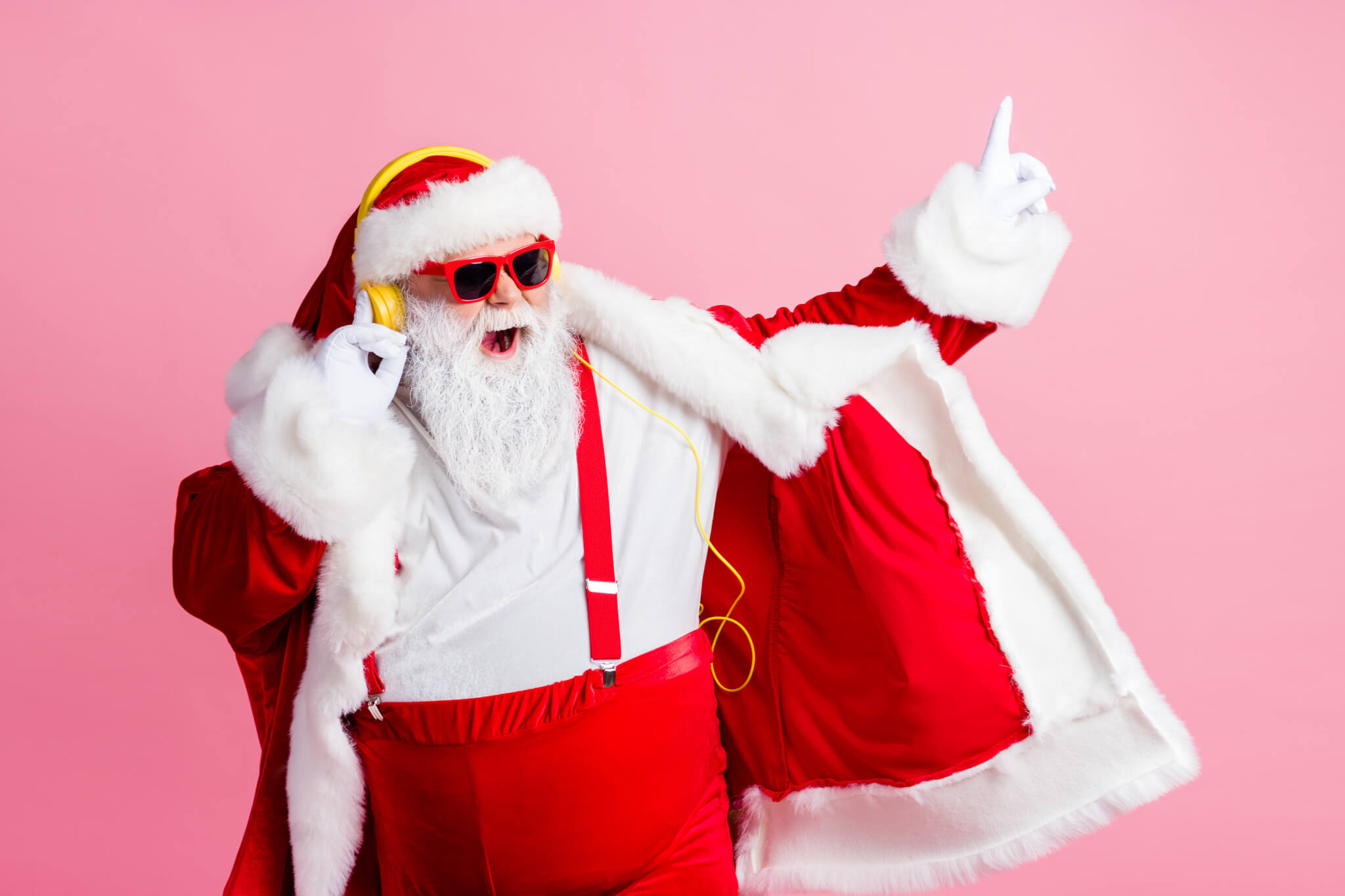Santa Claus listening to music on his headphones, dancing to Christmas songs