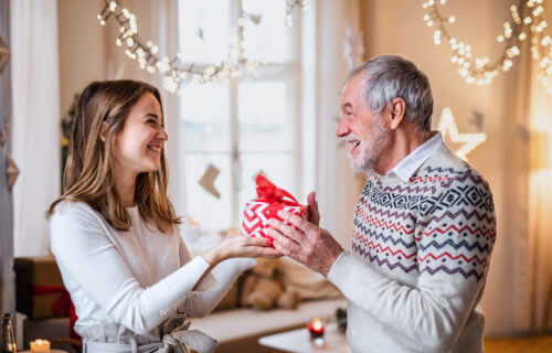 Woman giving her dad a Christmas gift