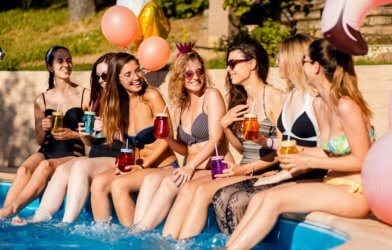 Women sitting by the pool at a bachelorette party