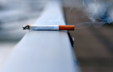 Lit cigarette burning on a ledge