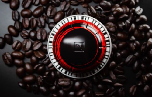 Pod for Nespresso coffee machine, sitting atop beans