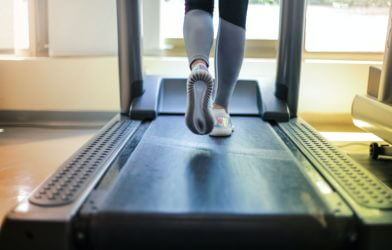 Woman getting exercise at gym by running on treadmill