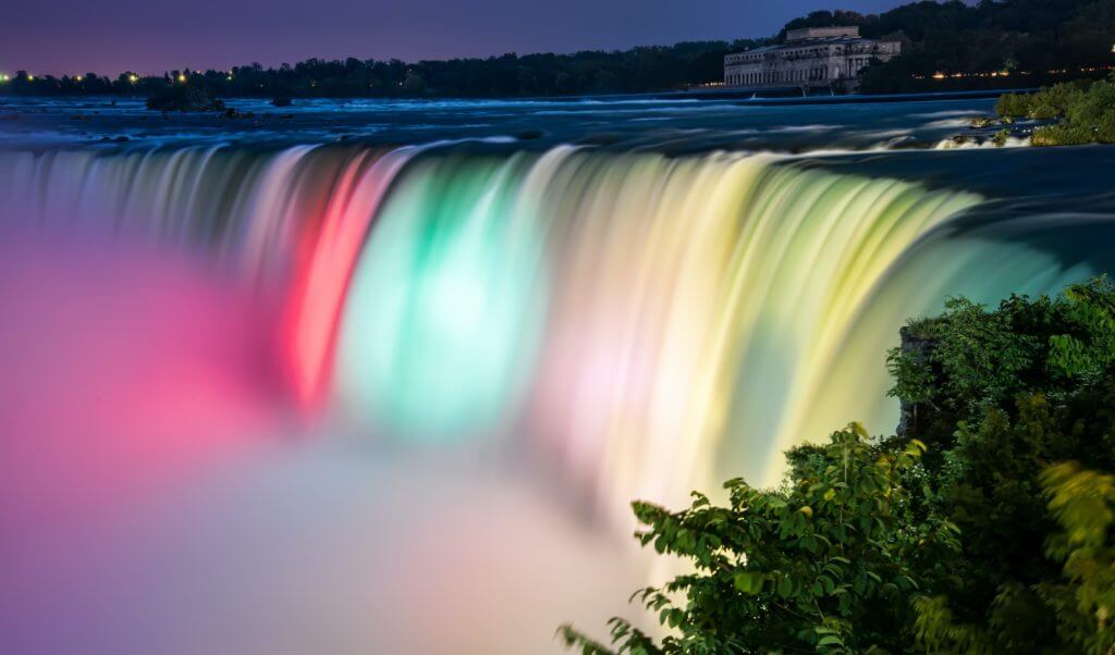 Beautiful view of Niagara Falls in Ontario, Canada lit up with colors.