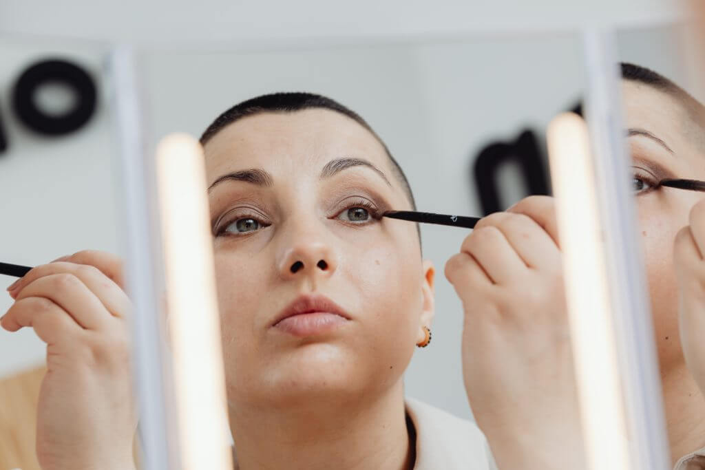 Femme appliquant un eye-liner dans le miroir