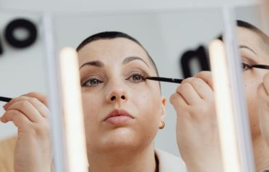 Woman applying eyeliner in mirror