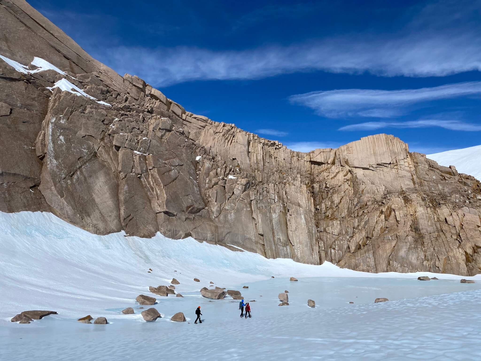 The team hiking past rock formations in Antarctica. 