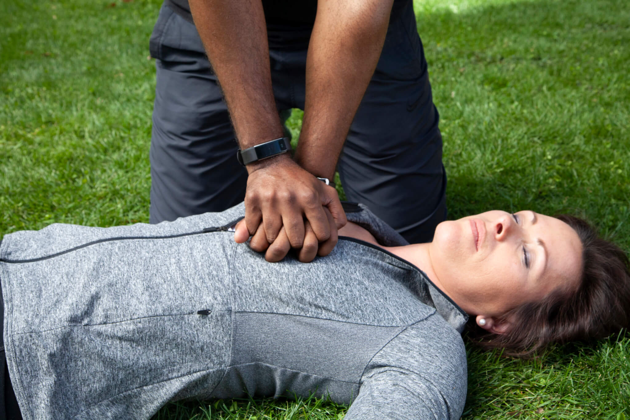 A man preforms CPR on an unconscious woman