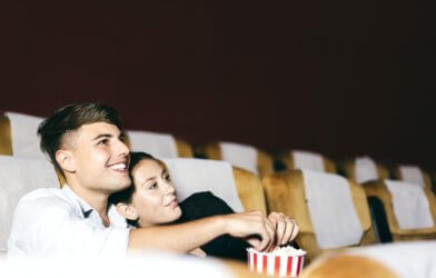 Couple watching a romance movie at the theater eating popcorn