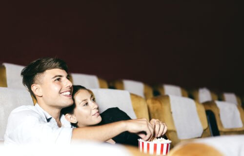 Couple watching a romance movie at the theater eating popcorn