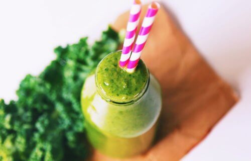 Delicious green smoothie in a bottle with straws