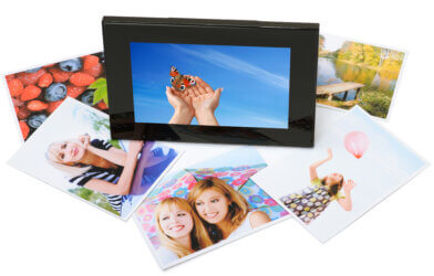 Digital picture frame surrounded by photos