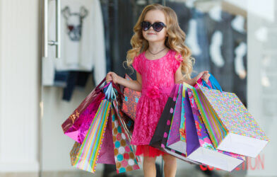 Cute little girl with sunglasses on going on a shopping spree