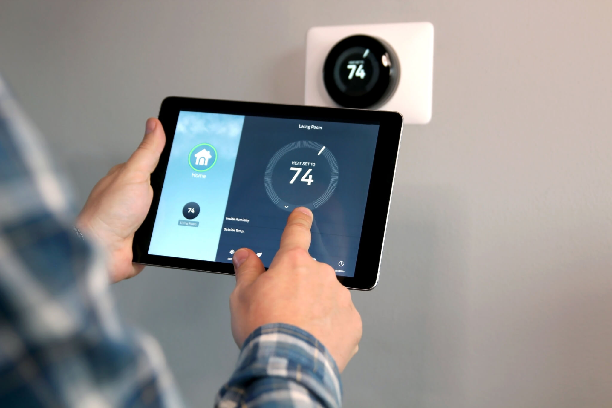 Man using a smart thermostat on his tablet
