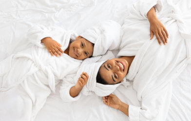 Mother and daughter lying on a bed in their bathrobes