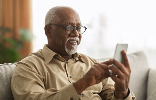 Older man sending a text message on his smartphone