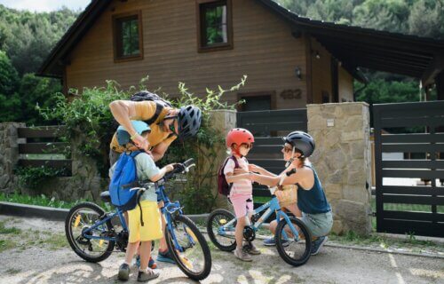 Parents putting bike helmets on their children