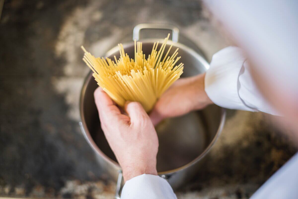 Spaghetti pasta placed into pot of water