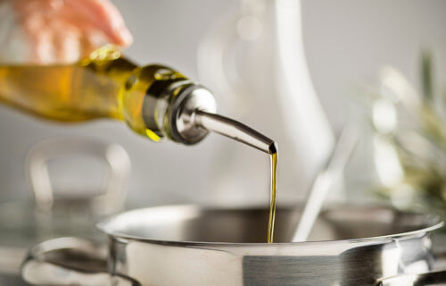 Cooking oil being poured into a pot for meal prep