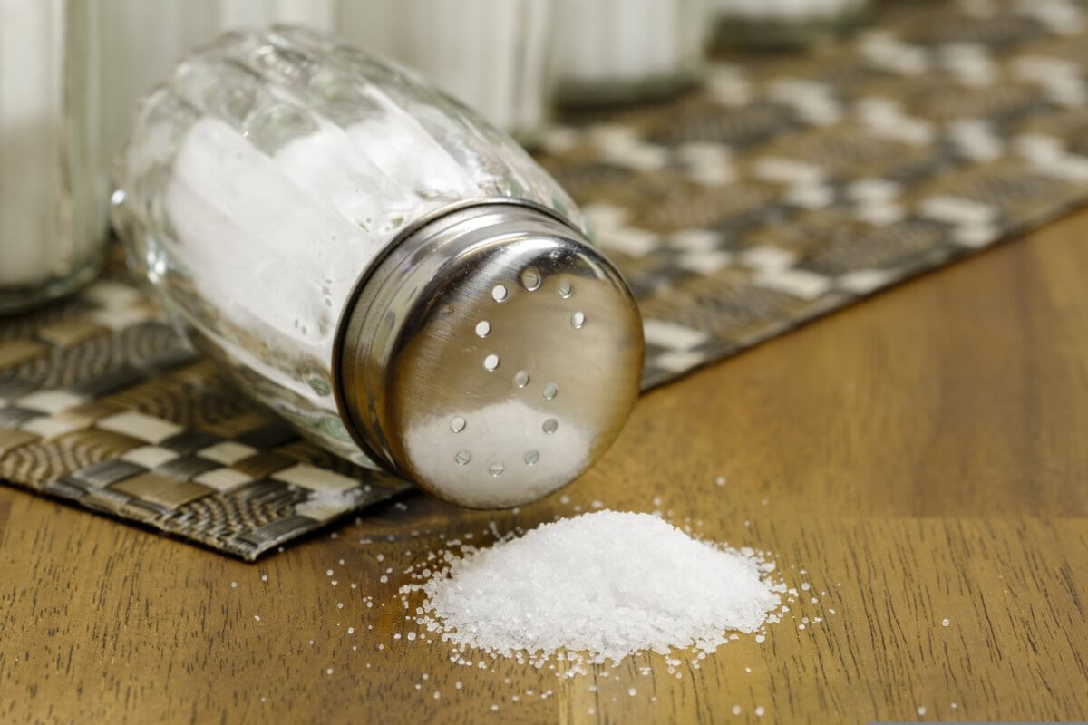 Salt shaker with salt poured onto table