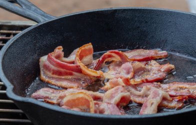 Sizzling bacon being cookied in a skillet