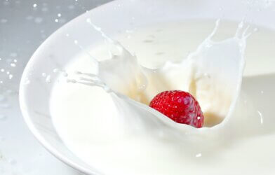 Strawberry splashing into bowl of milk