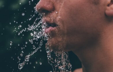 Drinking water splashing into a man's face