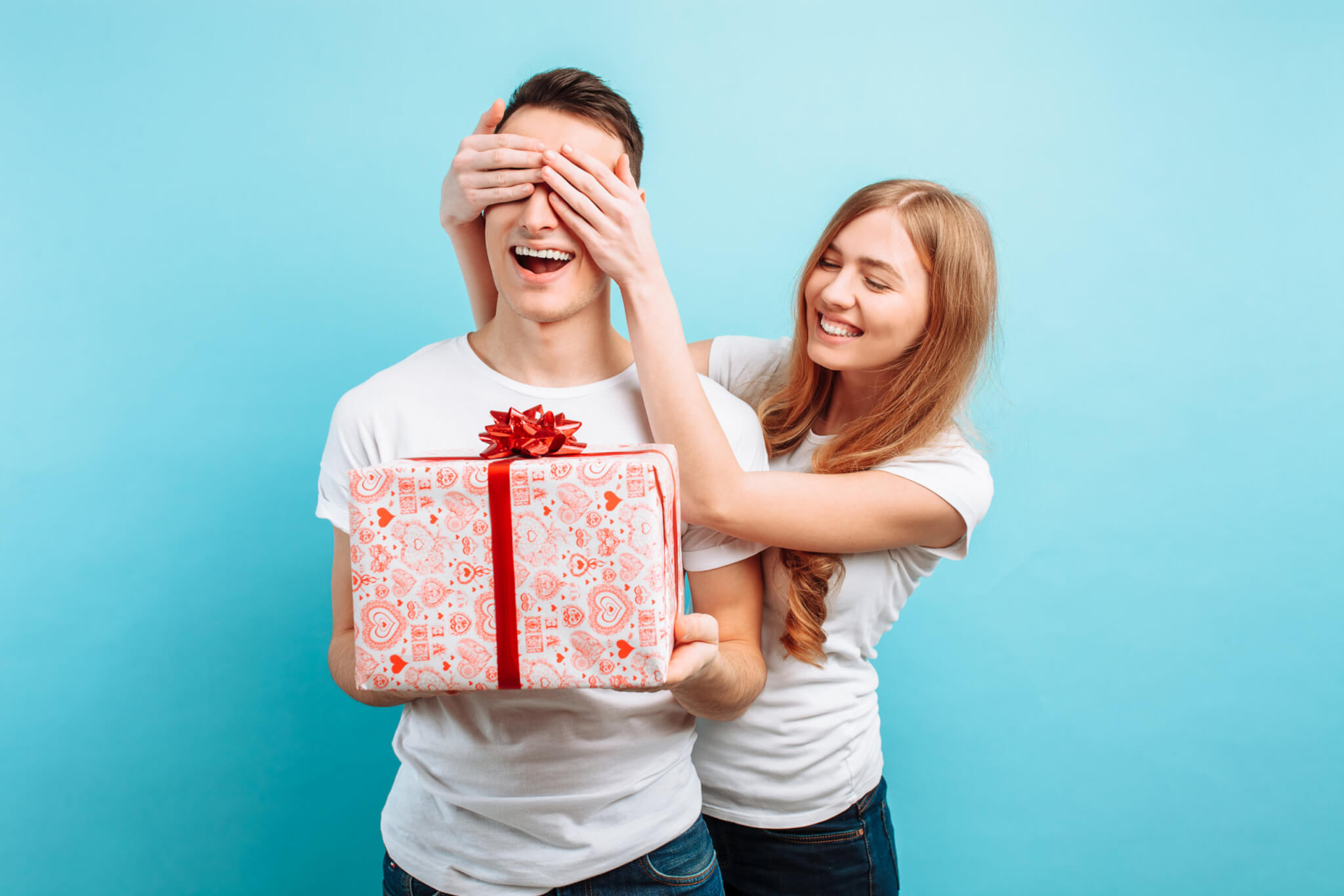 Woman surprises her boyfriend or husband with a gift on Valentine's Day