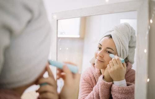 Woman using instant wrinkle eraser while looking at herself in the mirror