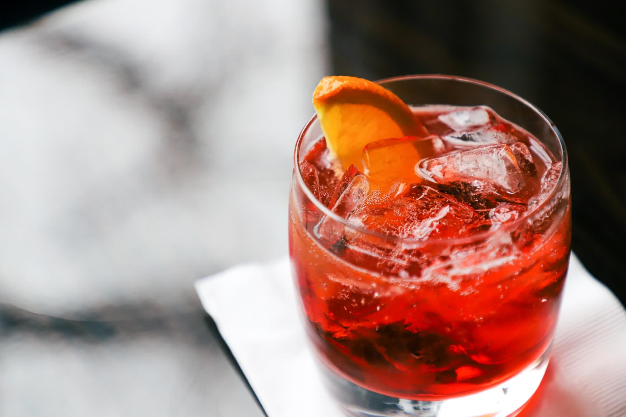 a negroni cocktail sitting on a bar