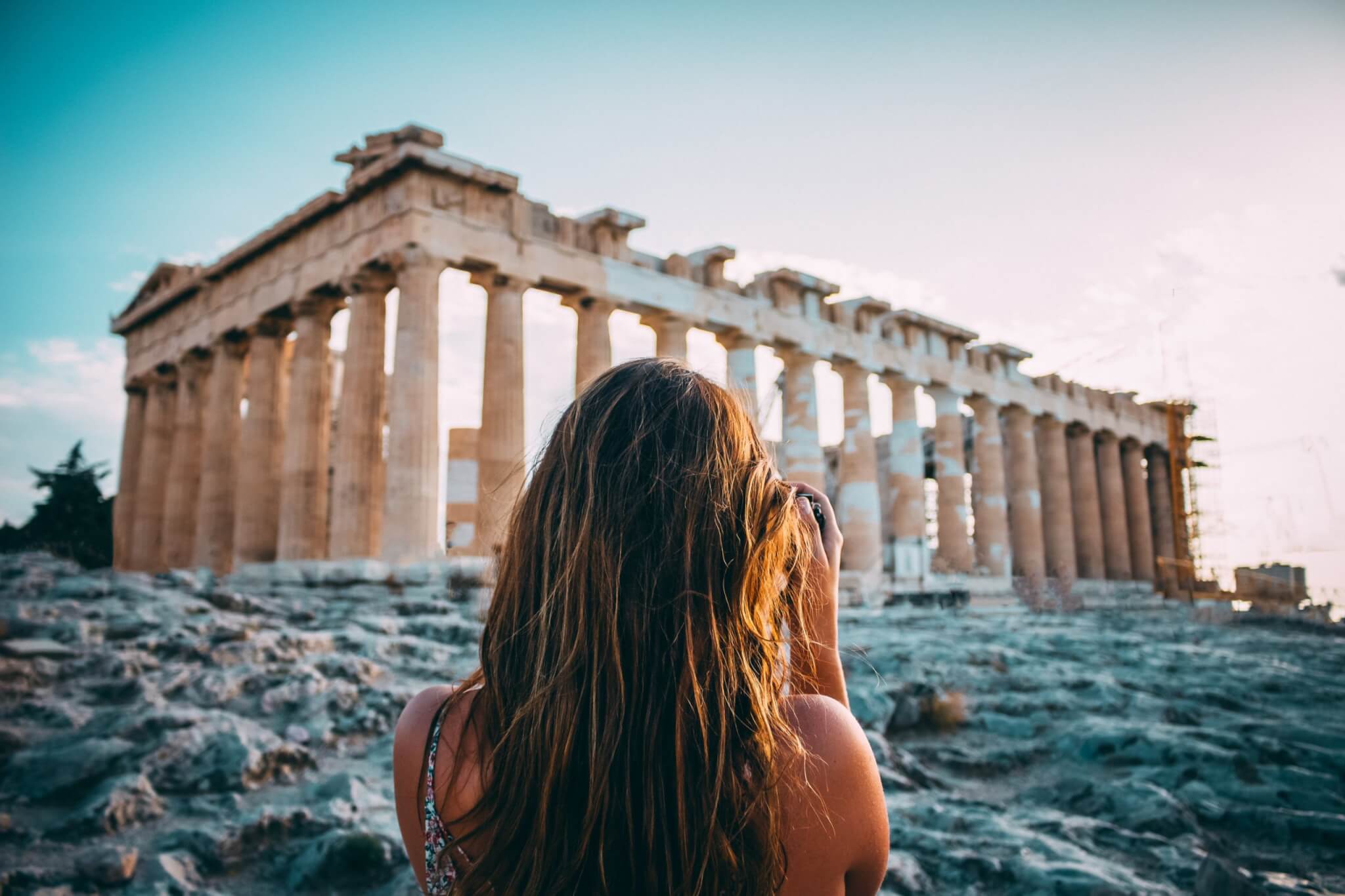 A woman taking a picture of The Parthenon in Athens