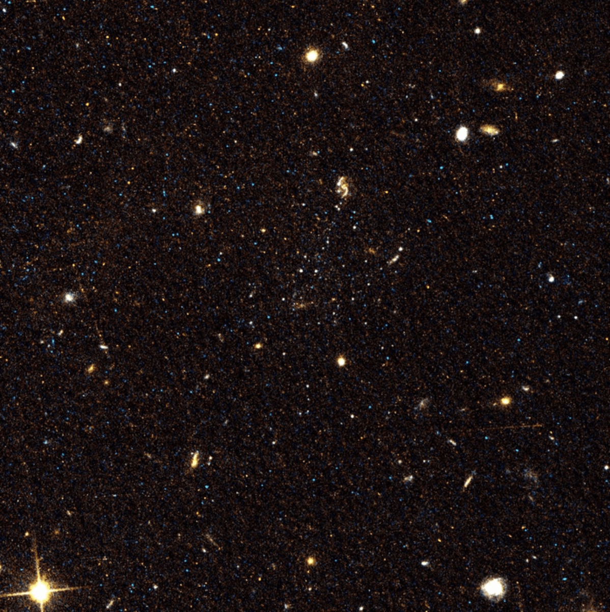 Image of space where three faint dwarf galaxies sit near a spiral galaxy.