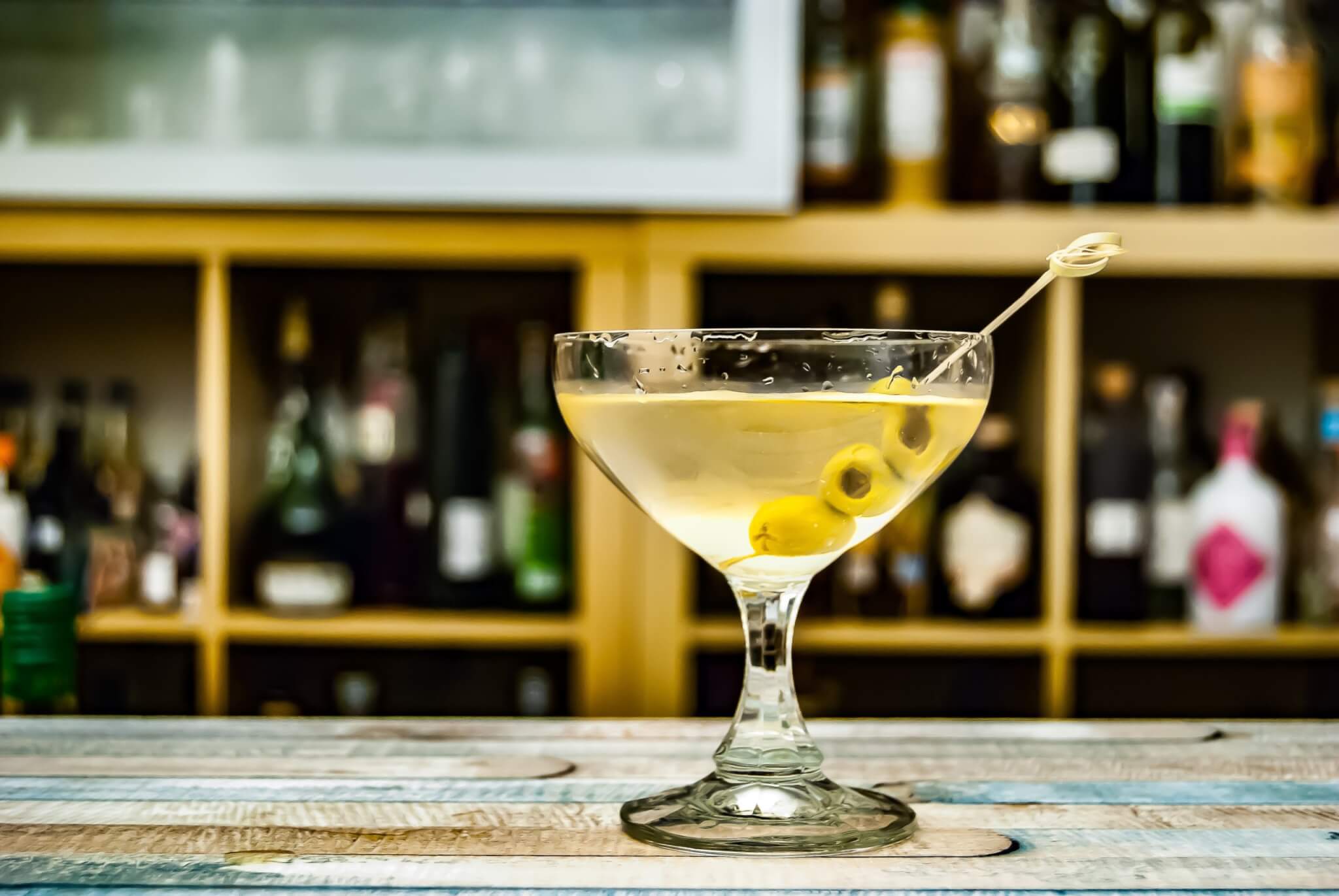 a dirty martini sitting on a bar