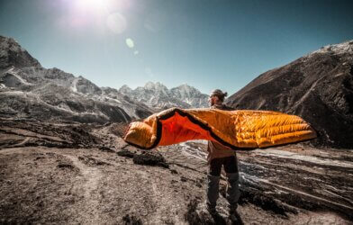 Man holding a sleeping bag on a mountain