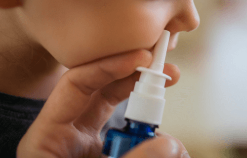 Person using a nasal spray on a child
